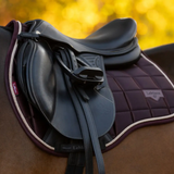 Close-up of a horse saddle with a blurred autumn background