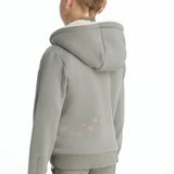 Child wearing a light green hoodie with decorative hoof print elements on a white background