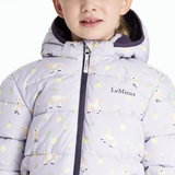 Child wearing a light purple puffer jacket with sheep pattern and 'LeMieux' branding.