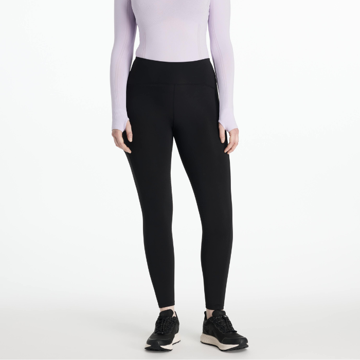 Person wearing black leggings and a light purple long-sleeve top on a white background