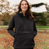 Person wearing a black jacket with 'LeMieux' branding outdoors.