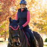 Person riding a horse with autumn trees in the background