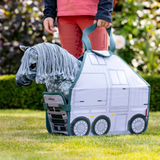 Child holding a toy truck with a horse inside, outdoors.