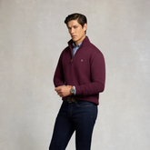 Holland Cooper Classic Quarter Zip Sweat (Men's) Variant Colour Mulberry. A male model wearing a mulberry coloured sweater and blue jeans on grey background.
