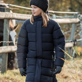 Person wearing a navy puffer coat, beanie, and gloves standing outdoors.