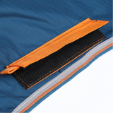 Close up of a velcro attachment in orange on a blue rug with a white background