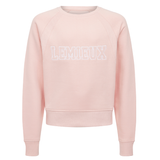 LeMieux AW26 Young Rider Shay Varsity Crew Varient Petal. A light pink crewneck sweatshirt with 'LEMIEUX' printed across the chest in white outlined block letters, displayed on a clean white background.