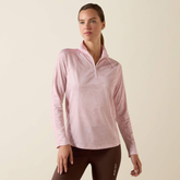 Woman wears a pink long sleeve top on a beige background