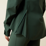 Green raincoat with a hood on a beige background