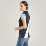 Girl wears a navy polo shirt with white stripe and grey sleeves on a plain background