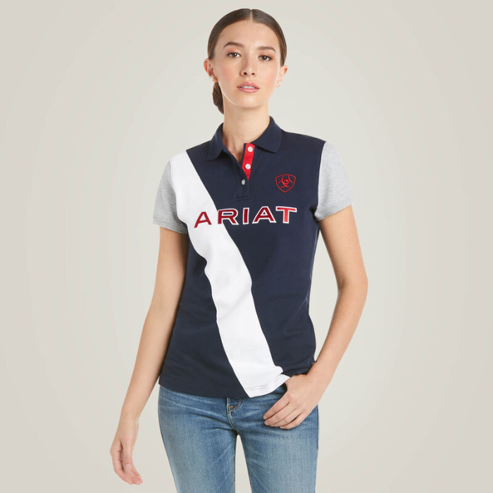 Girl wears a navy polo shirt with white stripe and ARIAT logo on a plain background