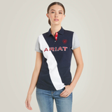 Girl wears a navy polo shirt with white stripe and ARIAT logo on a plain background