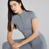 Woman wearing a light blue athletic outfit on a plain background