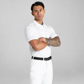 Man wearing a white polo shirt and breeches with a black belt on a grey background