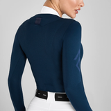 Close-up of a person wearing a blue sweater and white shirt on a grey background
