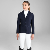 Young girl wears a navy blazer with white breeches on a grey background