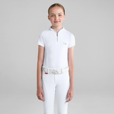 Young girl wears a white short sleeve base layer and white breeches on a grey background