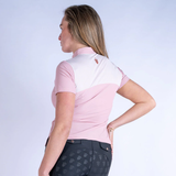 Woman wearing a pink polo shirt on a white background