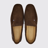 Pair of brown suede loafers on a light grey background