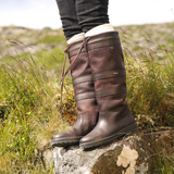 Brown country boots on a rock with grassy background