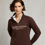 Woman wearing a brown Holland Cooper sweatshirt against a neutral background