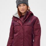 Woman wearing a red jacket with a brand logo on a light grey background