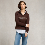Woman wearing a brown Holland Cooper sweatshirt against a plain background