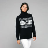 Woman wearing a black sweater with a white pattern on a grey background