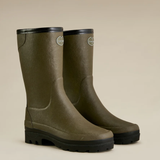Pair of green rubber boots with black soles on a beige background