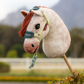 Plush horse toy with a headcollar against a blurred outdoor background