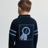 Navy blue shirt with a logo on the back worn by a child, on a light grey background