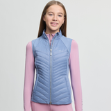 Girl wearing a blue quilted vest over a pink shirt on a light grey background