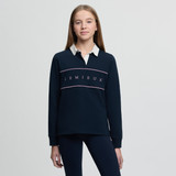 Person wearing a navy blue Lemieux sweater with a white collar on a light grey background