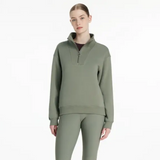 Person wearing a green sweatshirt with a quarter zip on a white background