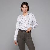 Woman wearing a white shirt with deer pattern and dark trousers on a grey background