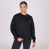 Woman wears a black sweatshirt against a grey background