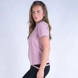 Woman wearing a pink athletic shirt with a logo on a white background