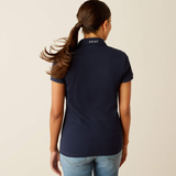 Person wearing a navy blue polo shirt with 'Ariat' logo on the back, standing against a beige background.