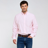 Man wearing a pink shirt and blue jeans on a pale background