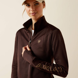 Woman wearing a brown Ariat jacket on a beige background