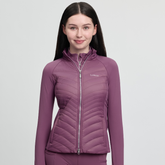 Woman wearing a pink quilted jacket on a light grey background