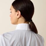 Woman with a ponytail wearing a checkered shirt against a beige background