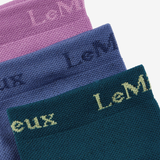 Close up of three coloured socks in pink, blue and navy with branding on a white background