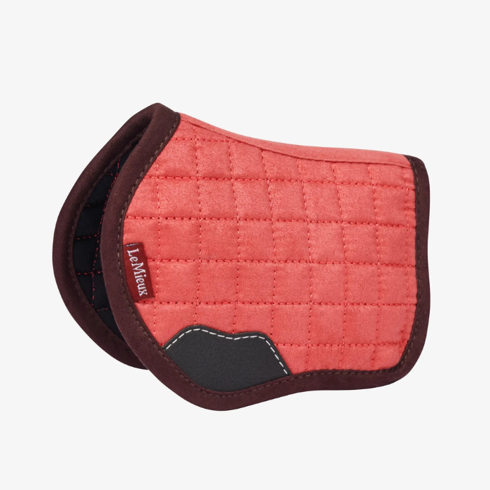 Red quilted horse saddle pad with brown border on a white background