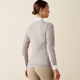 Woman wearing a light grey long-sleeve top with white trim on a beige background