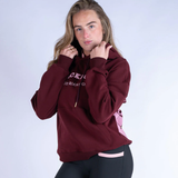 Person wearing a burgundy hoodie with text on a white background
