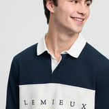Man wearing a navy and white polo shirt with 'LEMIEUX' branding on a light grey background