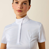 Woman wearing a light blue checkered shirt against a beige background