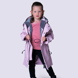 Young girl wears a pink rain coat with fleece lining against a white background