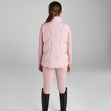 Person wearing a pink equestrian gilet and leggings with black boots on a grey background